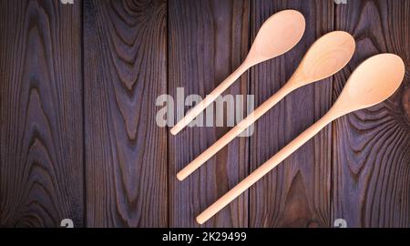 Tre cucchiai di legno su un tavolo di legno scuro. Foto Stock