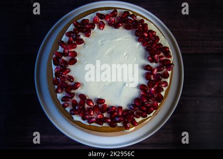 Torta a tre strati, composta da dolci e crema bianca, decorata con melograno in alto, vista dall'alto Foto Stock