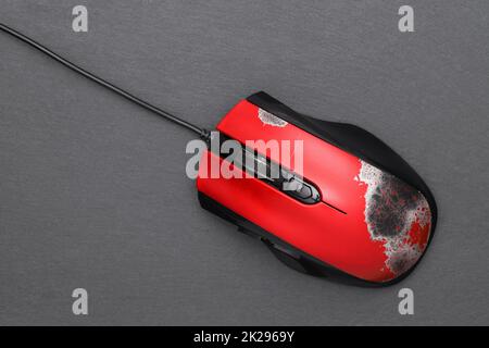 mouse del computer rotto con cavo di collegamento su sfondo grigio scuro Foto Stock