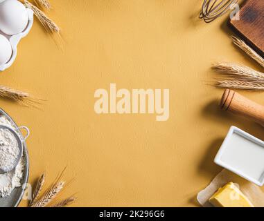 Cornice di ingredienti alimentari per la cottura su sfondo giallo. Piano cottura con spazio copia. Vista dall'alto. Concetto di cottura. Mockup. Foto Stock