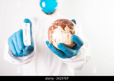 Medico che tiene il pianeta Terra e coronavirus test Foto Stock