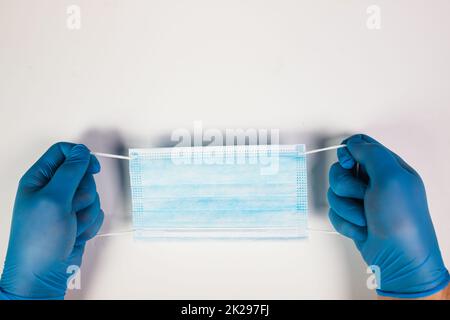 Primo piano della mano del medico che tiene la maschera chirurgica Foto Stock