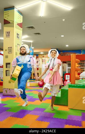 L'uomo e la donna come i bambini che tengono le mani che camminano insieme Foto Stock