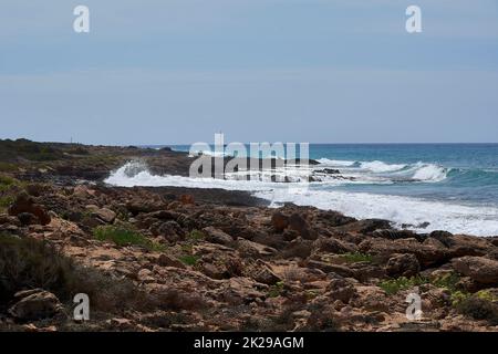 Rocce sulla riva colpite dall'onda Foto Stock