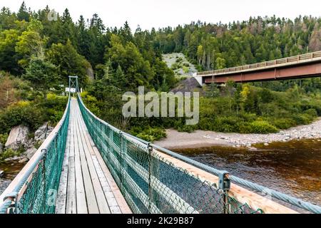 Vista sul ponte sospeso del fiume Big Salmon nel parco nazionale canadese di Fundy Foto Stock