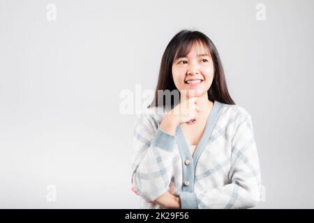 Donna felice mano toccare mento manico rilassato pensando a qualcosa circa la domanda Foto Stock