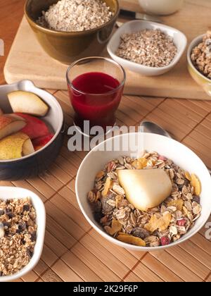 Ricca colazione con cereali biologici e ingredienti su un tavolo di legno Foto Stock
