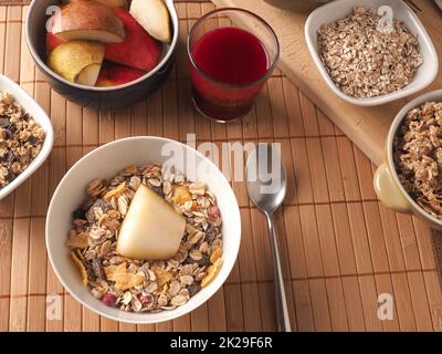 Ricca colazione con cereali biologici e ingredienti su un tavolo di legno Foto Stock