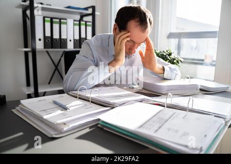 Stressato uomo contabile aziendale stanco Foto Stock