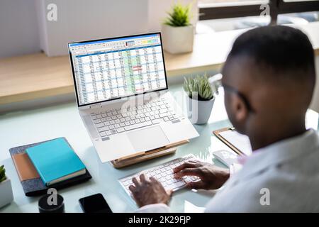 Analista dei dati African Man utilizzando un foglio di calcolo Foto Stock