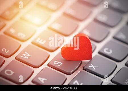 Piccolo cuore rosso sulla tastiera del computer. Internet Dating concetto. Foto Stock