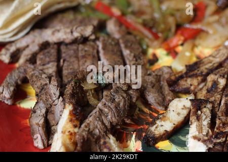 Fajita di manzo e pollo con cipolle e peperoni Foto Stock