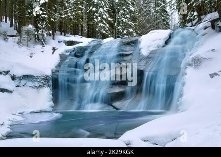 Acqua ghiacciata in repubblica Ceca acqua blu gradini neve su entrambi i lati pietra nera lunga esposizione Foto Stock