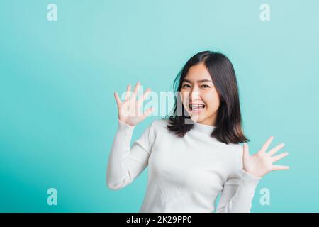 donna allegro trucco sorridente mostrando mani aperte Foto Stock