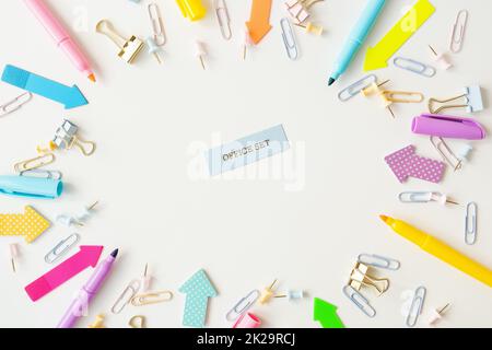 Cancelleria, forniture scolastiche su un tavolo bianco in colori pastello luminosi. Iscrizione. Foto Stock