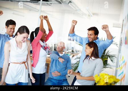 Theres non migliore lavoro che lavoro di squadra. Girato di un gruppo di uomini d'affari casualmente vestiti in ufficio. Foto Stock