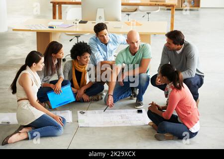 Theres non migliore lavoro che lavoro di squadra. Girato di un gruppo di uomini d'affari casualmente vestiti in ufficio. Foto Stock