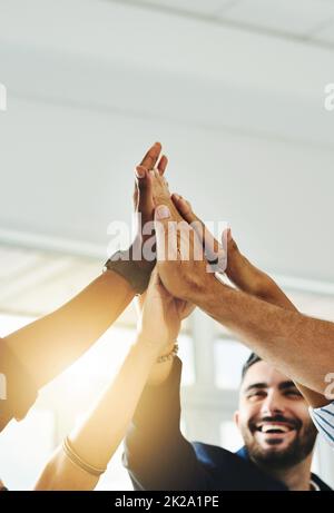 Motivato più che mai. Scatto corto di un gruppo di uomini d'affari alto che si fiving in un ufficio. Foto Stock