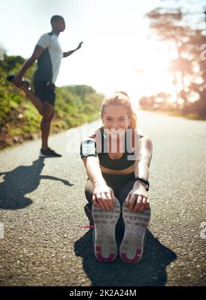 Preparare i muscoli per un allenamento straordinario. Scatto di una giovane donna che si allunga prima della sua corsa all'aperto. Foto Stock