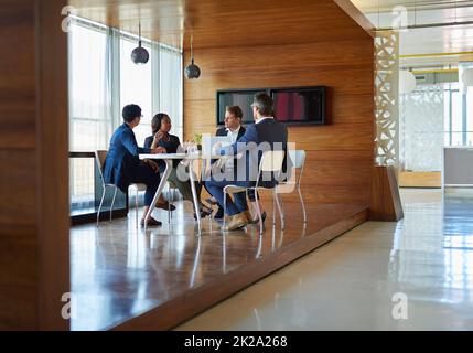 La riunione è sessione. Shot di un gruppo di uomini d'affari aziendali che lavorano nella sala riunioni. Foto Stock