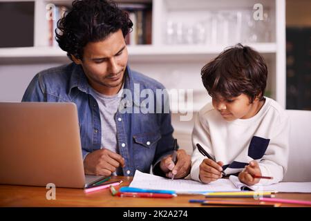 Un'attenta guida porta a ricompense ancora maggiori. Colpo di un padre che aiuta suo figlio con i suoi compiti. Foto Stock