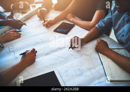 Unire il meglio dell'azienda. Scatto ritagliato di un gruppo di architetti che lavorano insieme su un progetto. Foto Stock