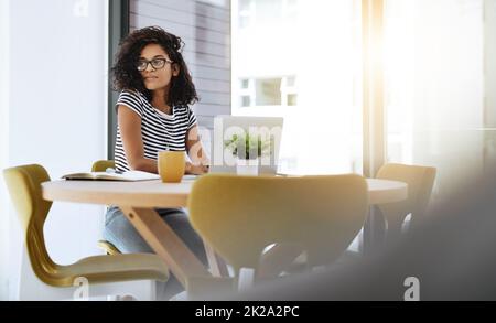 Pensare a modi per portare a termine il lavoro. Scatto di una giovane donna che lavora da casa. Foto Stock