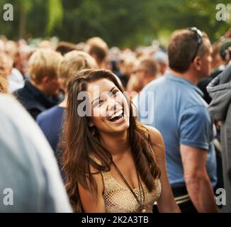 Il più divertente di sempre. Ritratto di una donna attraente ridendo in una folla in un festival musicale. Foto Stock