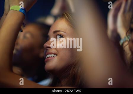 Ripresa di una giovane donna in una folla in un concerto. Questo concerto è stato creato per l'unico scopo di questo servizio fotografico, con 300 modelli e 3 band dal vivo. Tutte le persone in questo sparo sono modello rilasciato. Foto Stock