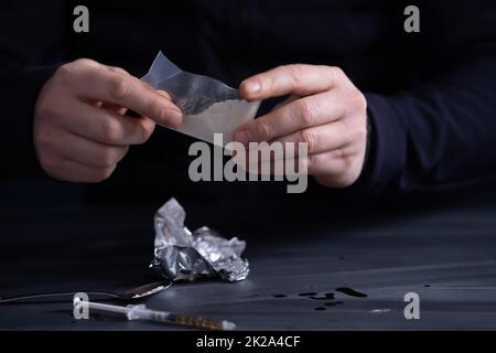 L'uomo tossicodipendente o il commerciante di droga prepara l'eroina. Foto Stock