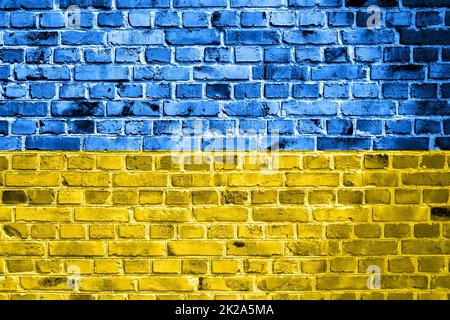 Bandiera nazionale dell'Ucraina dipinta su un muro di mattoni. Banner su vecchio sfondo muro di mattoni in crepe blu e giallo colori. Il concetto di relazioni tra i paesi - nessuna guerra tra Ucraina e Russia. Foto Stock