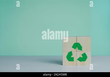 Cubo di legno con icona di riciclo e verde industriale. Concetto di business e sviluppo ecocompatibile in background. Foto Stock