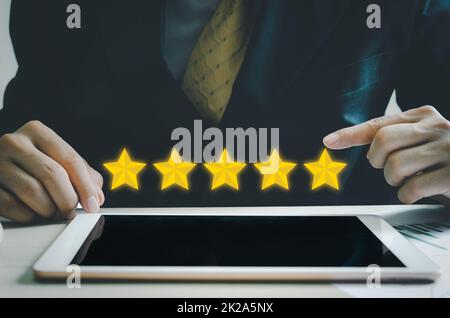 Concetto di cliente eccellente servizio per la soddisfazione cinque stelle con uomo d'affari touch screen su tablet.feedback e recensioni positive dei clienti. Foto Stock