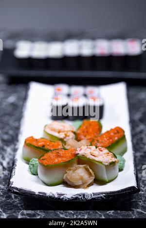 set di panini di sushi con frutti di mare su una pietra nera sfondo Foto Stock