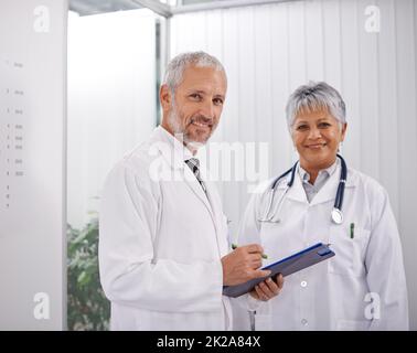 Consultare un collega per un secondo parere. Shot di due medici che lavorano insieme in un ospedale. Foto Stock