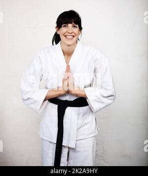 Master of the Martial Arts. Studio ritratto di una giovane donna che si inchinano nel suo karate gi. Foto Stock