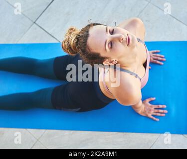 Faccio yoga perché mi calmi. Shot di una giovane atleta femminile che pratica lo yoga a casa. Foto Stock