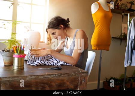 La moda nella realizzazione. Un giovane designer che fa un abbigliamento nel suo posto di lavoro. Foto Stock