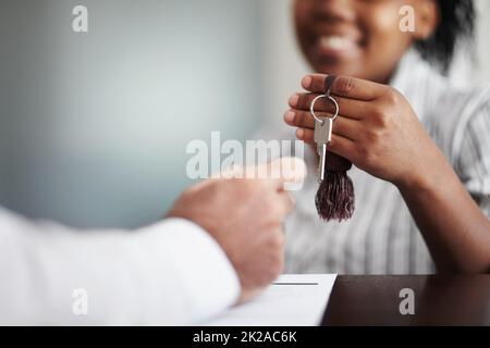 Non vorrete mai andarsene Primo piano di un receptionist che consegna le chiavi della camera d'albergo ad un senior patron. Foto Stock