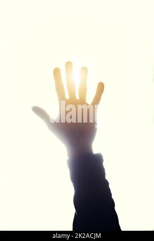 È luminoso. Scatto corto di una mano di persone alzate e bloccando il sole. Foto Stock