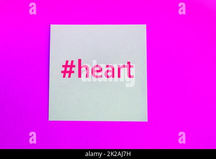 Hashtag parola cuore su sfondo bianco e carta rosa, piatto Foto Stock