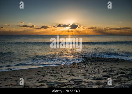 Una perfetta vista sul mare da una spiaggia al tramonto Foto Stock