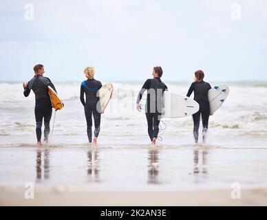 Il surf non è più rinvigorente. I giovani surfisti sono entusiasti di colpire le onde impressionanti. Foto Stock