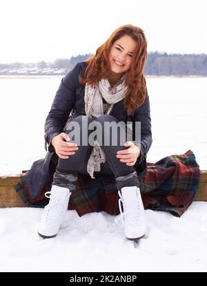 Inverni il mio periodo preferito dell'anno. Ragazza abbastanza adolescente pronta a pattinare su ghiaccio su un lago naturale ghiacciato all'aperto. Foto Stock