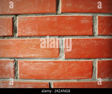 Frammento di muro di mattoni rossi primo piano. La struttura dello sfondo. Modello per un'iscrizione. Mockup per il design. Foto di alta qualità Foto Stock