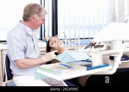 Medico che parla al suo paziente. Ritratto di medico maturo che parla al suo paziente in clinica. Foto Stock