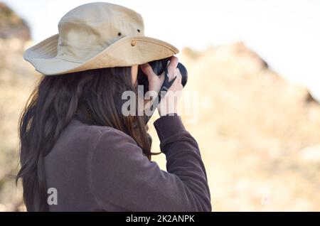 Catturare il selvaggio. Una giovane donna che scatta foto all'esterno. Foto Stock