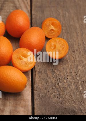 Kumquat biologici freschi su un rustico tavolo da cucina in legno Foto Stock