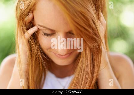 Potrebbe essere timida, ma la sua bellezza brilla attraverso. Primo piano di una bella ragazza adolescente all'aperto. Foto Stock