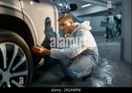 Processo di controllo della vernice della carrozzeria della vettura da parte del pittore Foto Stock